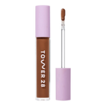 Tower 28 Beauty Swipe Serum Concealer in the shade 17.0 SD, shown with the tube standing upright next to the open applicator wand to reveal the product. [17.0 SD]