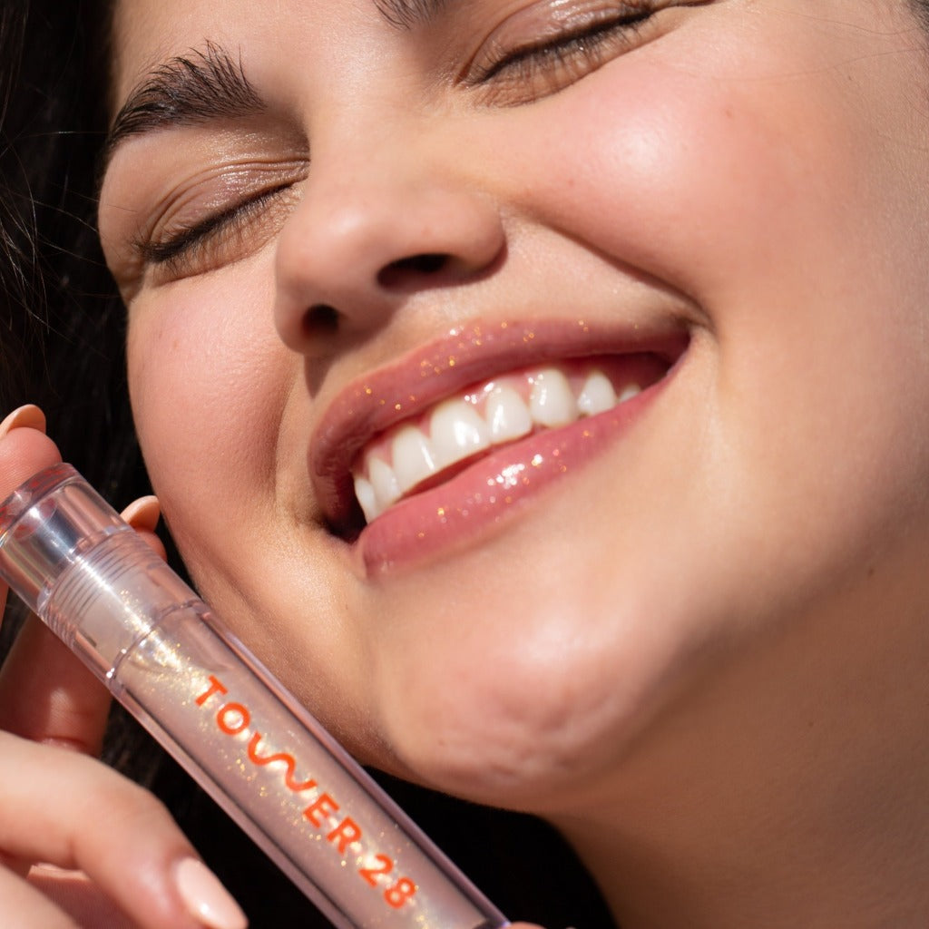 A model wearing the Tower 28 Beauty ShineOn Lip Jelly in the shade Magic on her lips. [Magic]